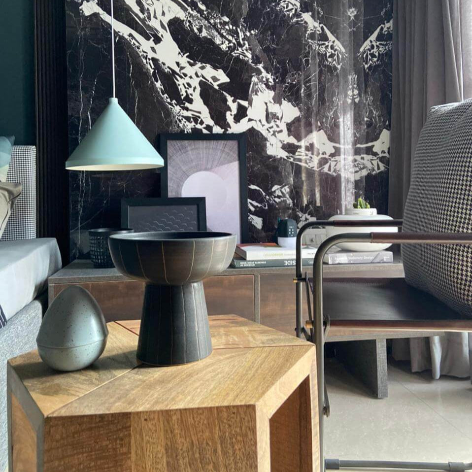 Modern living room with wooden coffee table, decorative items, and a large abstract painting.