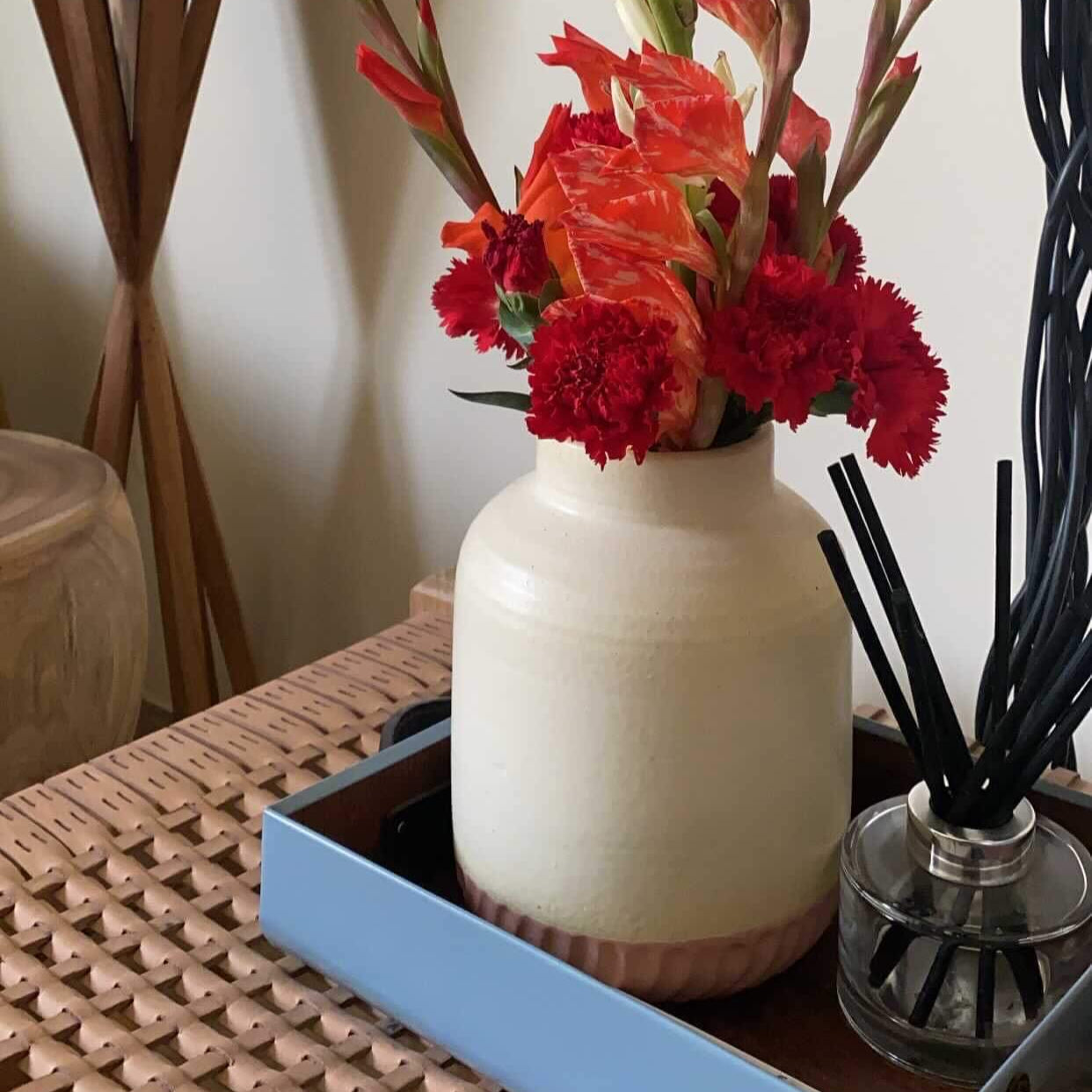 Vase with flowers on a table next to decorative items